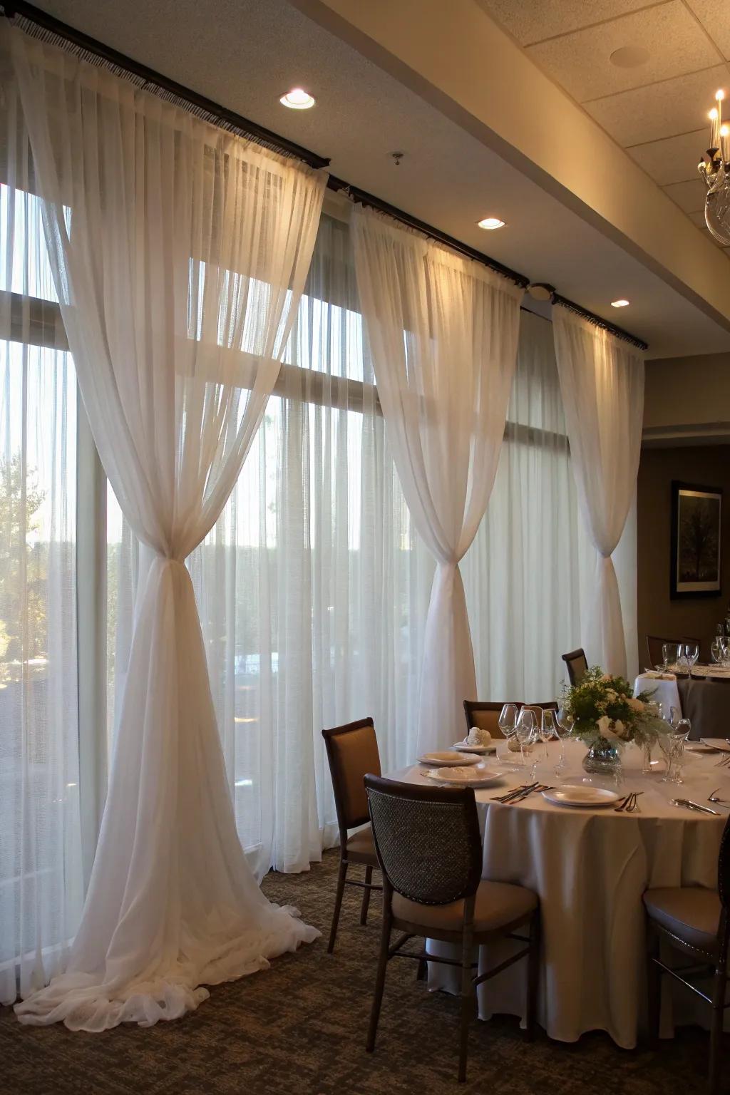 Sheer curtains bring elegance to a temporary wall in a dining area.