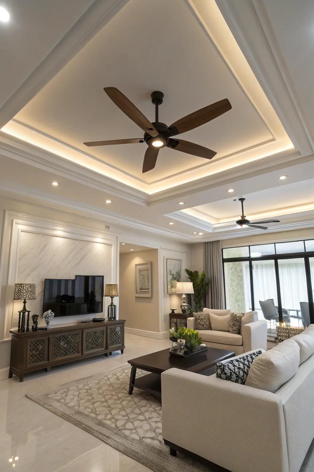 A modern living room featuring a sleek ceiling fan with lighting in the tray ceiling.