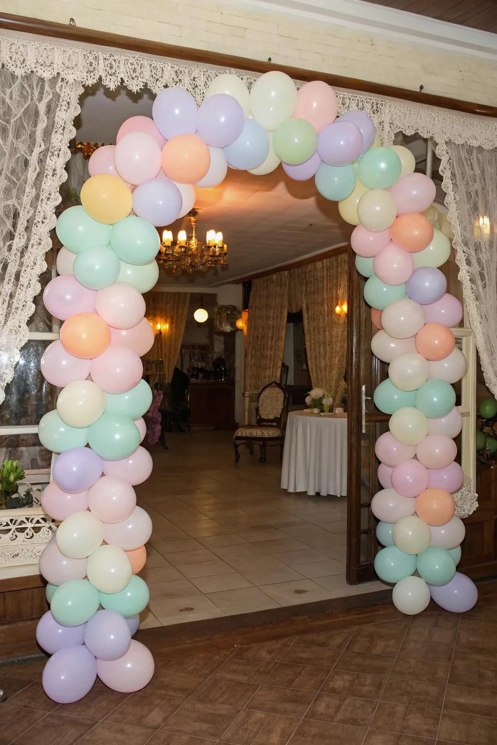 A whimsical pastel balloon arch welcoming guests.