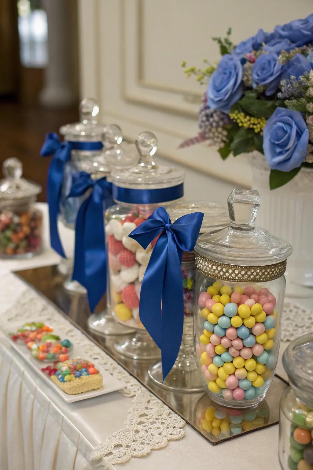 Candy jars elegantly decorated with royal blue ribbons.